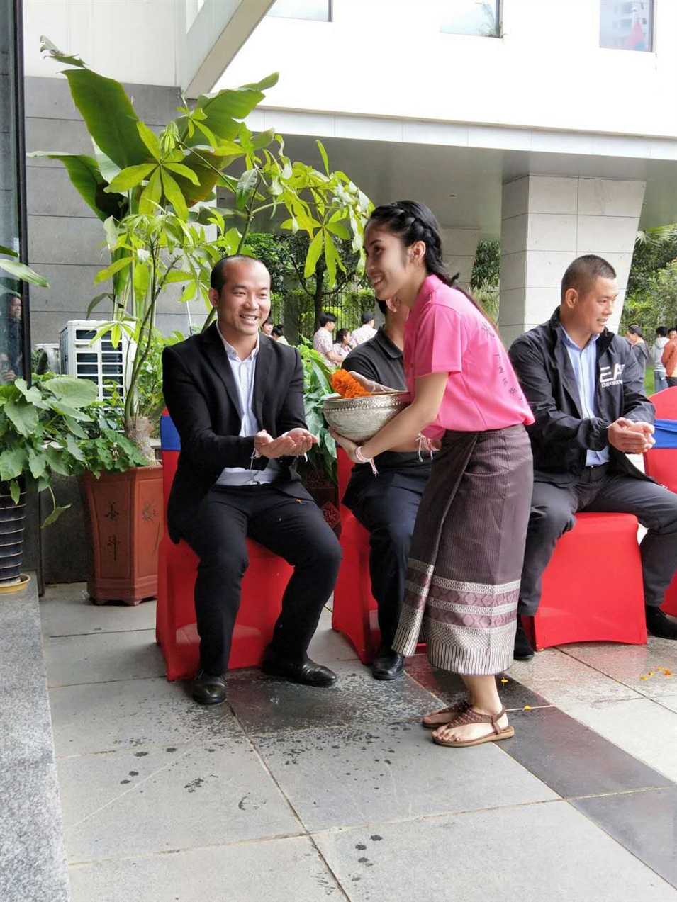 老撾駐廣西留學(xué)生代表將浸有花瓣的香水灑客人的手上，表示對嘉賓的美好祝福（圖一）